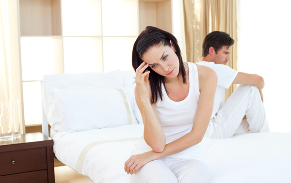 Upset couple finding out results of a pregnancy test in the bedroom