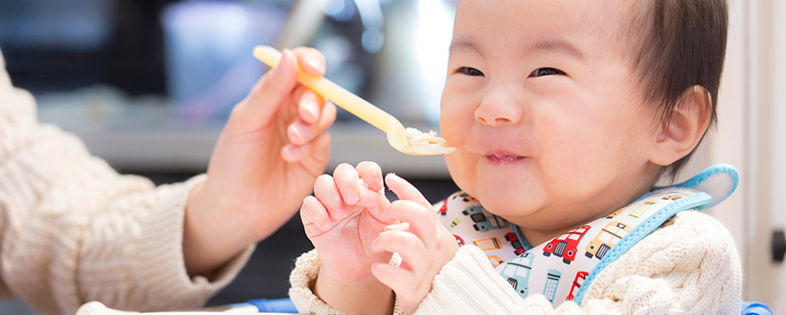 Bebê experimentando novos alimentos para testar alergias alimentares para bebês