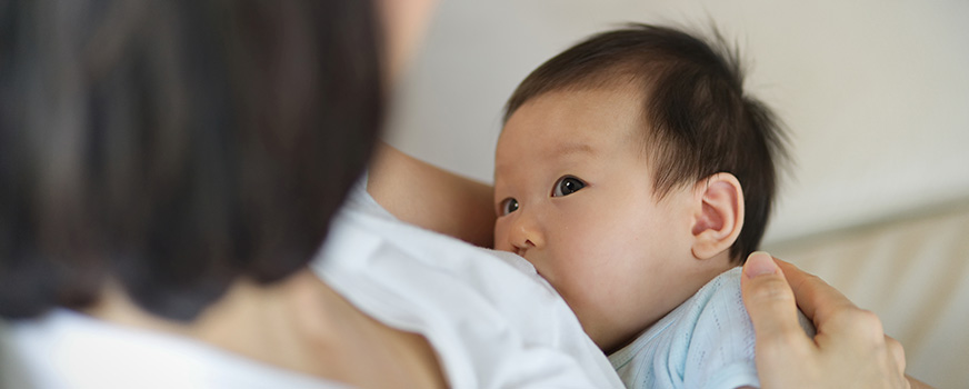 Child Looking at Mother While Breastfeeding