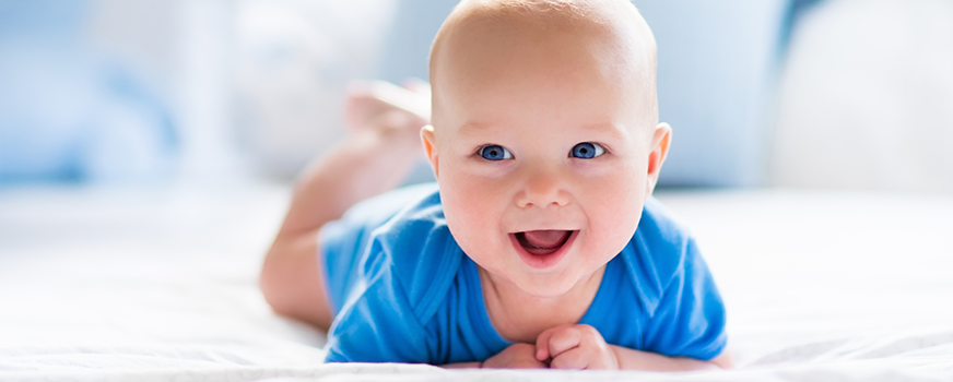 Bebé feliz en una cama a prueba de niños