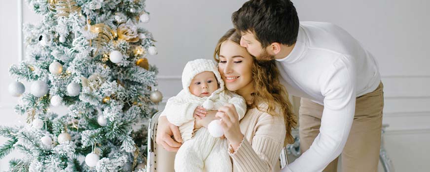 Familia feliz celebrando la primera Navidad del bebé