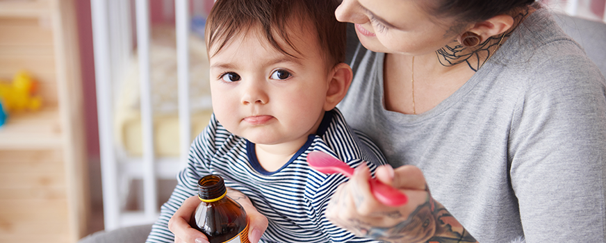 Mãe dando remédios para bebê doente