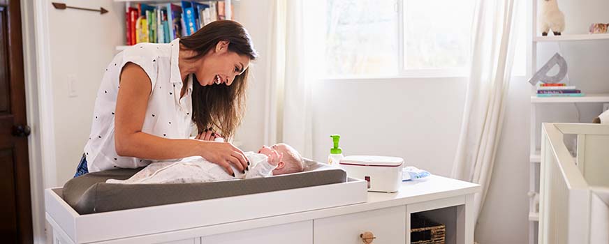 Nueva mamá usando cambiador y accesorios