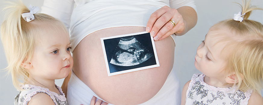 Madre embarazada con gemelos y ultrasonido.