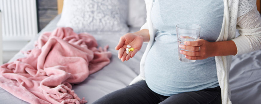 Pregnant Woman About to Take Prenatal Vitamins