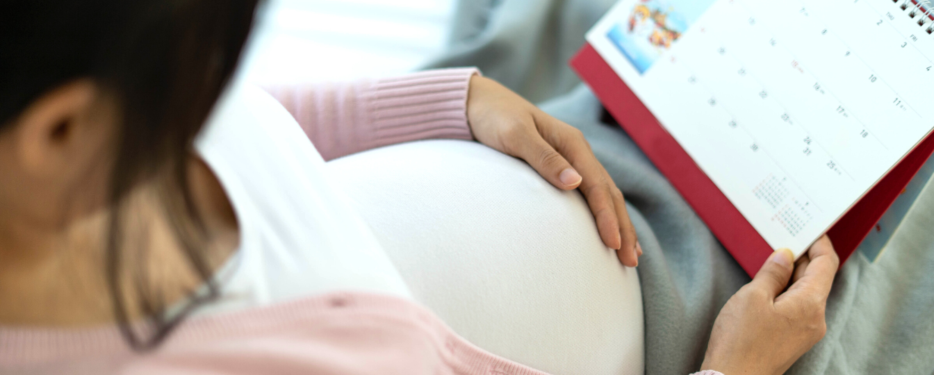 Pregnant Woman Looking at Calendar for Birth Due Date