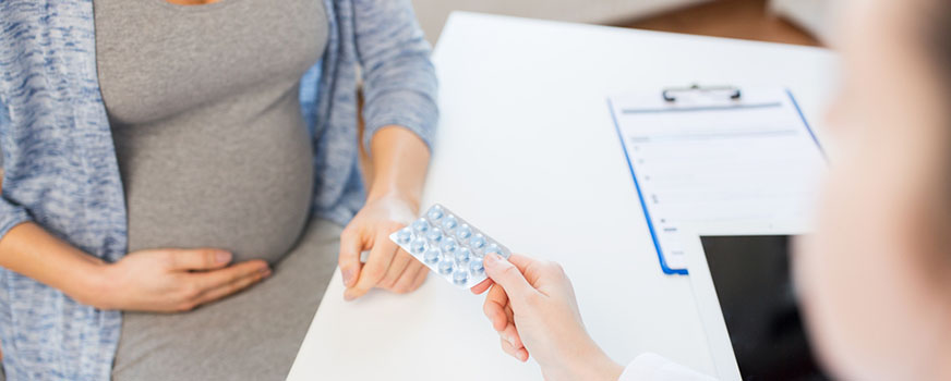 Mujer embarazada hablando con el médico sobre las vitaminas prenatales