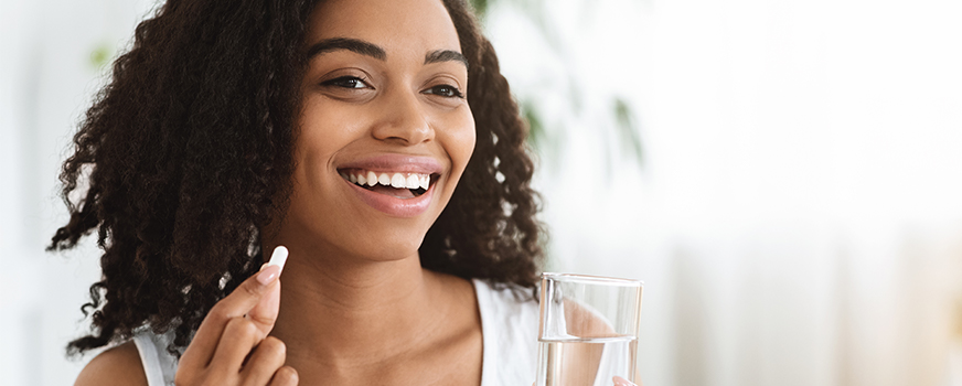 Woman Taking Supplement for Morning Sickness Remedy