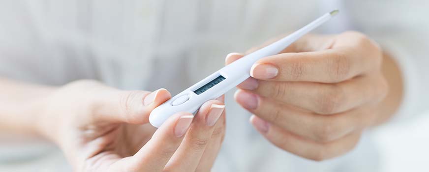 Woman Holding Thermometer for Basal Body Temperature