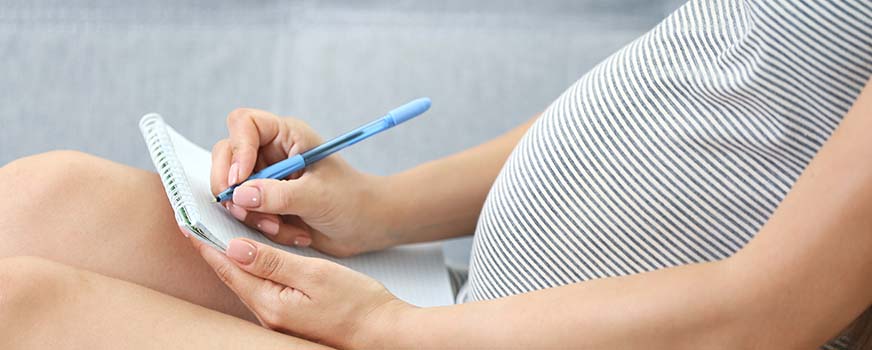 Woman Taking Birth Plan Notes at Childbirth Class