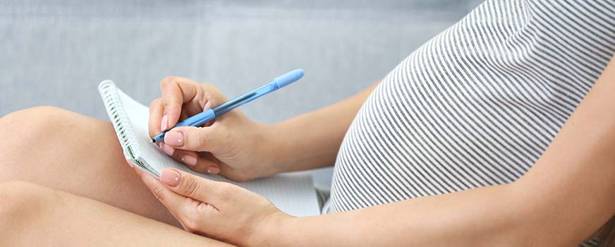 Mujer tomando notas del plan de parto en clase de parto