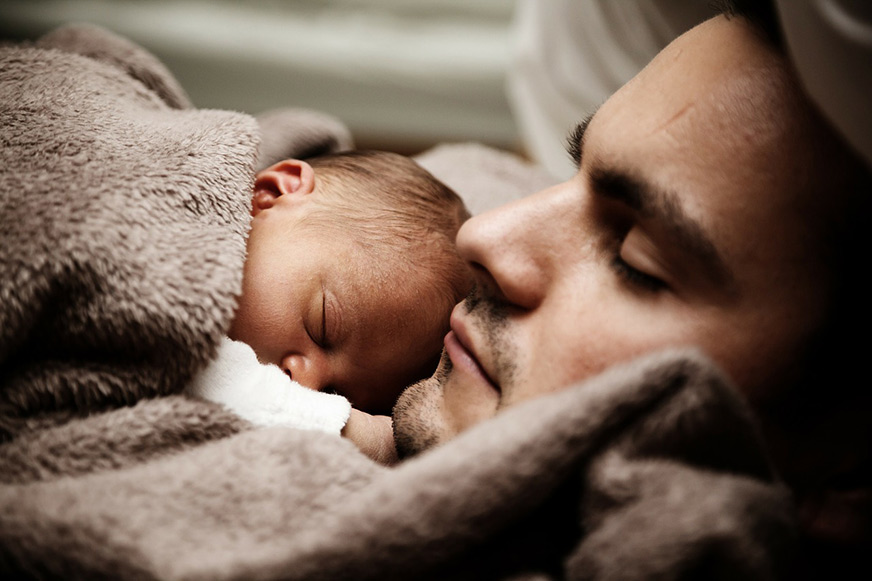dad sleeps with newborn baby